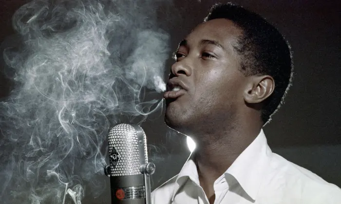 A photo of Sam Cooke smoking into his microphone